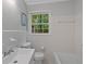 Bright, tiled bathroom features a white sink, toilet, and tub under a window with a lovely outdoor view at 4781 Lincoln Ne Dr, Kennesaw, GA 30144