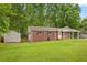 Charming brick house featuring a covered front porch, well-manicured lawn, and an adjacent shed at 4781 Lincoln Ne Dr, Kennesaw, GA 30144