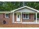 Close up of the brick exterior with a white door, shutters and a covered carport at 4781 Lincoln Ne Dr, Kennesaw, GA 30144