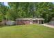 Charming brick home with a well-manicured lawn, convenient carport, and storage shed at 4781 Lincoln Ne Dr, Kennesaw, GA 30144