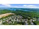 Overhead view of the community with tree lined roads and a large lake in the background at 1156 Whisper Cove Dr, Buford, GA 30518