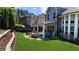 Green backyard features ample lawn space and a cozy patio with outdoor seating at 1156 Whisper Cove Dr, Buford, GA 30518