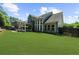 Lush backyard with ample lawn space, a covered patio, and tasteful landscaping at 1156 Whisper Cove Dr, Buford, GA 30518