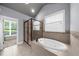 Bathroom featuring soaking tub with tiled surround and glass shower at 1156 Whisper Cove Dr, Buford, GA 30518