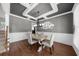 Formal dining room featuring decorative trim, hardwood flooring, and stylish chandelier at 1156 Whisper Cove Dr, Buford, GA 30518