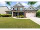 Charming brick two-story home with manicured lawn and attached two-car garage at 1156 Whisper Cove Dr, Buford, GA 30518