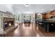 Living room featuring fireplace, large windows, hardwood floors, and an open kitchen with island at 1156 Whisper Cove Dr, Buford, GA 30518