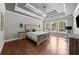 Main bedroom showcasing a tray ceiling, hardwood floors, and three large windows for natural light at 1156 Whisper Cove Dr, Buford, GA 30518