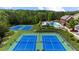 Picture of community tennis courts with a community pool off in the background and plenty of trees at 1156 Whisper Cove Dr, Buford, GA 30518