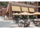 Exterior shot showing the patio of Honeysuckle Biscuits and Bakery with black metal tables and chairs at 1975 Flying Scotsman Dr # 18, Kennesaw, GA 30144