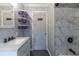 Bathroom featuring granite vanity with purple shelving and marble accent wall at 3844 Davis St, Suwanee, GA 30024
