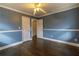 Blue bedroom showcasing hardwood floors, ceiling fan, and two doors at 3844 Davis St, Suwanee, GA 30024