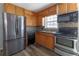 Kitchen features wood cabinets, stainless steel appliances, and laminate flooring at 3844 Davis St, Suwanee, GA 30024