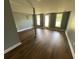 Finished basement space with dark wood-look flooring, a support beam, and a glass door at 5191 Nw Emory Nw St, Covington, GA 30014
