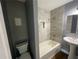 Remodeled bathroom with tub, white vanity, updated shower tile, and dark gray walls at 5191 Nw Emory Nw St, Covington, GA 30014