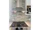 Modern kitchen showcasing a stainless steel range hood, cooktop, and contemporary backsplash at 5191 Nw Emory Nw St, Covington, GA 30014