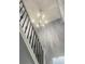 Staircase with wrought iron railing illuminated by a decorative chandelier at 5191 Nw Emory Nw St, Covington, GA 30014