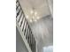 View of the staircase illuminated by a modern chandelier at 5191 Nw Emory Nw St, Covington, GA 30014