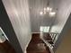 View of a staircase with gray walls and a chandelier overhead at 5191 Nw Emory Nw St, Covington, GA 30014