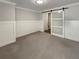 Bedroom featuring plush carpeting, white walls, decorative wainscotting and a frosted glass barn door at 108 Hickory Run, Canton, GA 30115