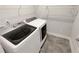 Laundry room with modern washer and dryer units and tile flooring at 108 Hickory Run, Canton, GA 30115