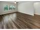 An empty living room with new wood laminate flooring, a ceiling fan, and natural lighting at 108 Hickory Run, Canton, GA 30115