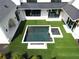 Stylish pool and spa with fire feature are surrounded by artificial turf in this modern home's backyard at 1210 Mayfield Rd, Milton, GA 30009