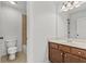Bathroom featuring a vanity with a mirror, neutral tiling, and a view to the commode and shower at 1345 Hilltop Overlook Dr, Marietta, GA 30062