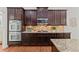 Modern kitchen design with stainless steel double ovens, cooktop, granite countertops and dark wood cabinets at 1345 Hilltop Overlook Dr, Marietta, GA 30062