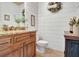Farmhouse bathroom featuring wood cabinets, granite countertop, and shiplap walls at 209 Wynnward Way, Sharpsburg, GA 30277