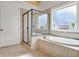 Modern bathroom featuring a tiled bathtub with shower and a window at 209 Wynnward Way, Sharpsburg, GA 30277
