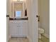 Nicely updated half-bath with granite countertop, tiled floors, and a decorative mirror at 209 Wynnward Way, Sharpsburg, GA 30277