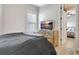 Cozy bedroom with neutral tones, hardwood floors, and television, with an adjoining room visible at 209 Wynnward Way, Sharpsburg, GA 30277