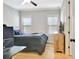 Comfortable bedroom with a ceiling fan, light gray walls, hardwood flooring, and a rustic wood dresser at 209 Wynnward Way, Sharpsburg, GA 30277