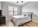 Bright bedroom with neutral paint, a large window, hardwood floors, and a stylish black dresser at 209 Wynnward Way, Sharpsburg, GA 30277