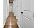 Hallway features hardwood floors and white walls offering a clean, modern aesthetic with a long, narrow perspective at 209 Wynnward Way, Sharpsburg, GA 30277