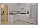 Elegant kitchenette with granite countertops, tiled floors, custom cabinetry and stainless steel appliances at 209 Wynnward Way, Sharpsburg, GA 30277
