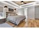 Bedroom featuring hardwood floors, tray ceiling, and stylish decor at 209 Wynnward Way, Sharpsburg, GA 30277