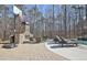 Outdoor fireplace with lounging and dining spaces next to a sparkling pool at 209 Wynnward Way, Sharpsburg, GA 30277