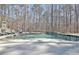 Beautiful pool with a built-in stone fireplace, lounge chairs, and natural surroundings for ultimate relaxation at 209 Wynnward Way, Sharpsburg, GA 30277