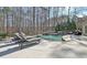 Inviting backyard pool with lounge chairs, a serene waterfall feature, and mature trees providing privacy at 209 Wynnward Way, Sharpsburg, GA 30277