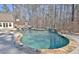 Large in-ground pool surrounded by lush greenery and mature trees offers a private oasis for swimming and relaxation at 209 Wynnward Way, Sharpsburg, GA 30277
