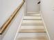 A well-lit staircase featuring light wood treads and a classic white risers and stringer at 209 Wynnward Way, Sharpsburg, GA 30277