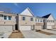 Inviting townhome featuring light brickwork, a two-car garage, and a neat front lawn under a blue sky at 4525 Twinberry Dr, Powder Springs, GA 30127