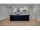 Contemporary kitchen with a large dark island, white cabinets, and stylish pendant lights overhead at 4525 Twinberry Dr, Powder Springs, GA 30127