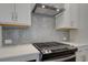 New kitchen features tile backsplash and stainless steel stove at 4525 Twinberry Dr, Powder Springs, GA 30127