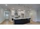 Modern kitchen featuring a dark island, pendant lighting, stainless appliances, and sleek countertops at 4525 Twinberry Dr, Powder Springs, GA 30127