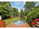 Lush backyard featuring a deck with a round pool surrounded by vibrant flowers and greenery at 120 Candler Oaks Ln, Decatur, GA 30030