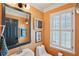 Well-lit bathroom with modern fixtures, a framed mirror, and a shuttered window at 120 Candler Oaks Ln, Decatur, GA 30030