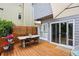 Inviting outdoor patio featuring a dining table, wooden deck, and entertainment TV with sliding door access at 120 Candler Oaks Ln, Decatur, GA 30030